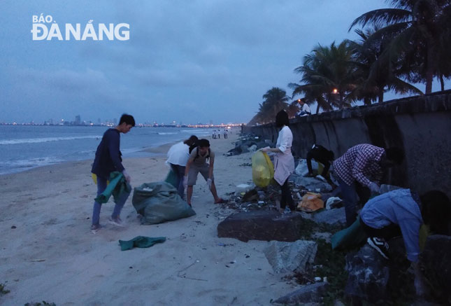 Flywheel members are seen picking up litter at sections of the coastal embankment system along coastal Nguyen Tat Thanh Street